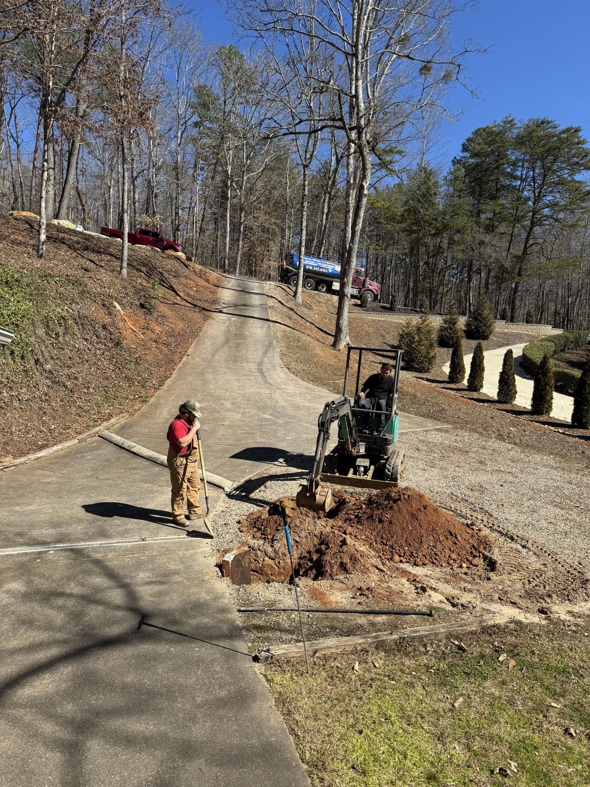 Crew servicing a septic system in a residential backyard