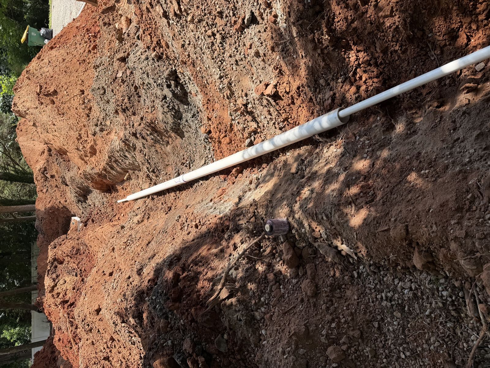 Septic tank installed in the ground with riser and pipe fittings