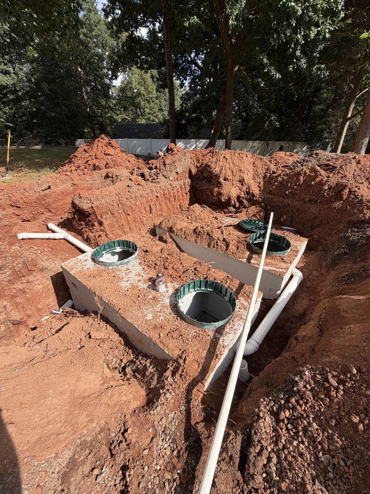 Drainfield trench with pipe runs installed near a house