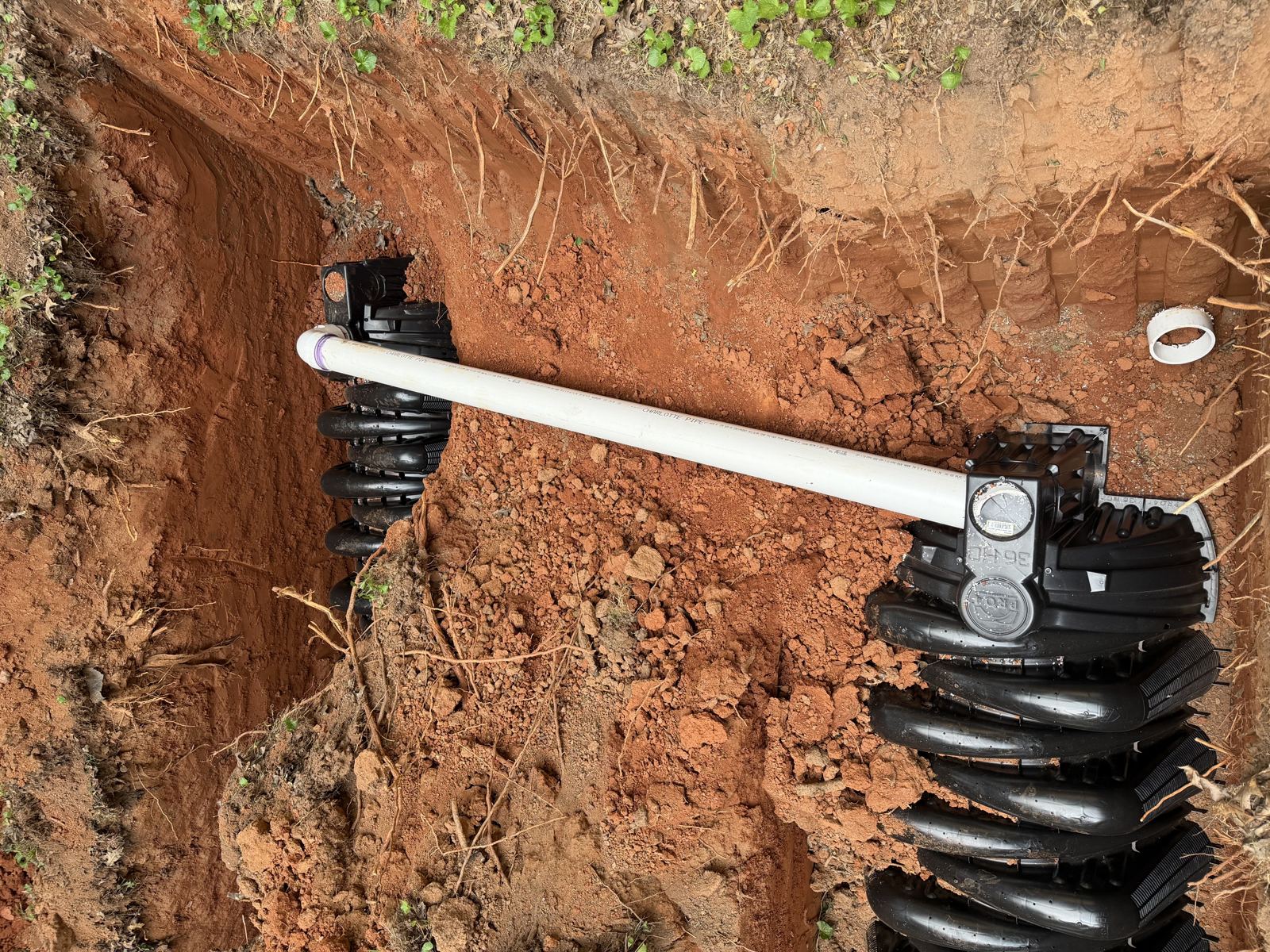 Crew installing drainfield pipe in a trench — Grease Trap Pumping in Lawrenceville, GA