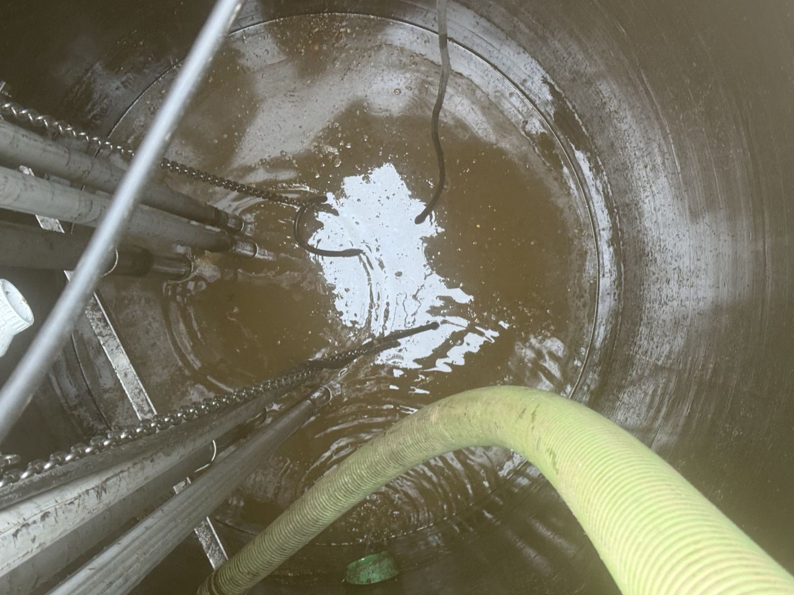Lift station wet well being pumped out with a suction hose