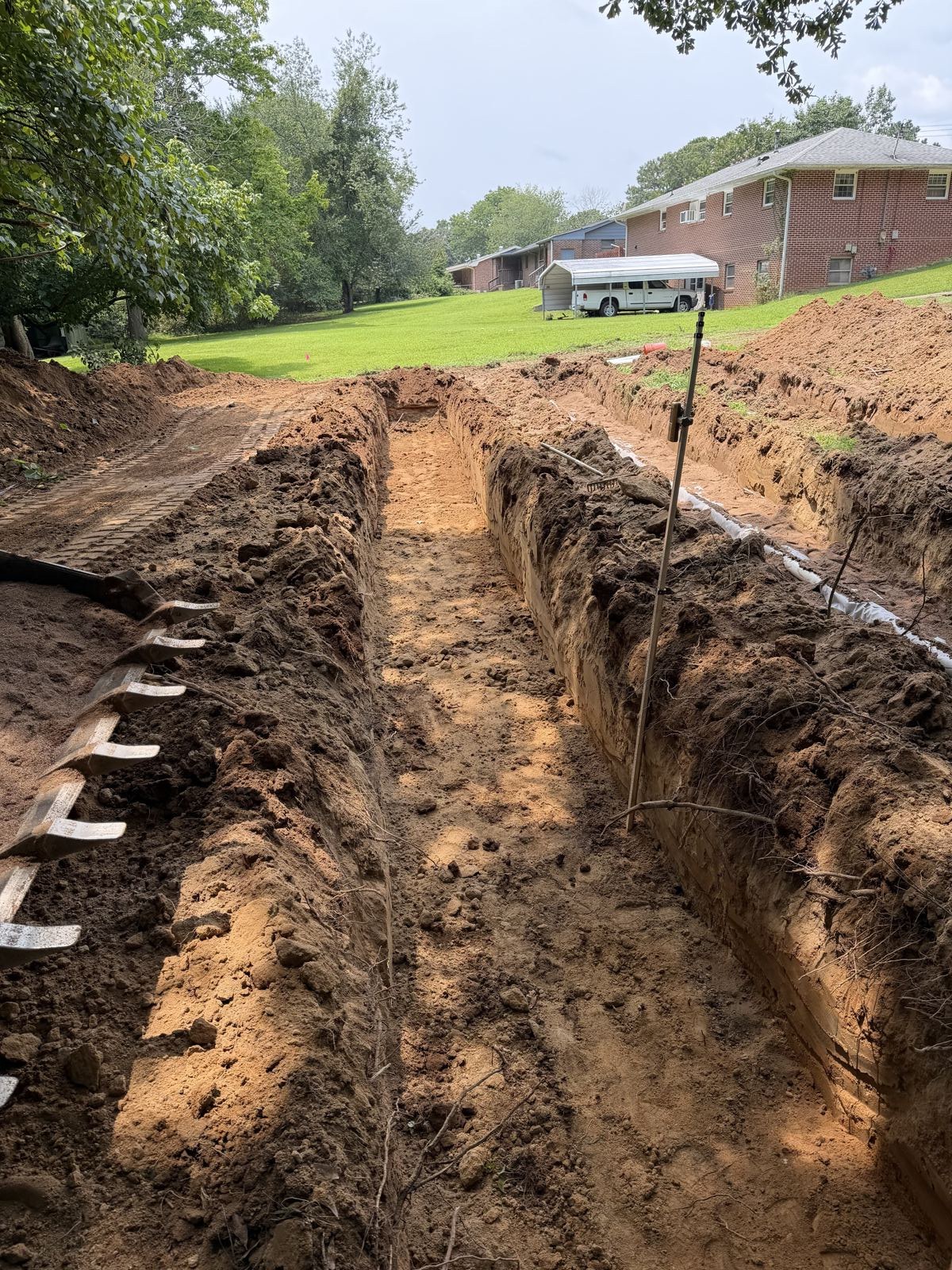 Drainfield trench with white distribution pipe runs