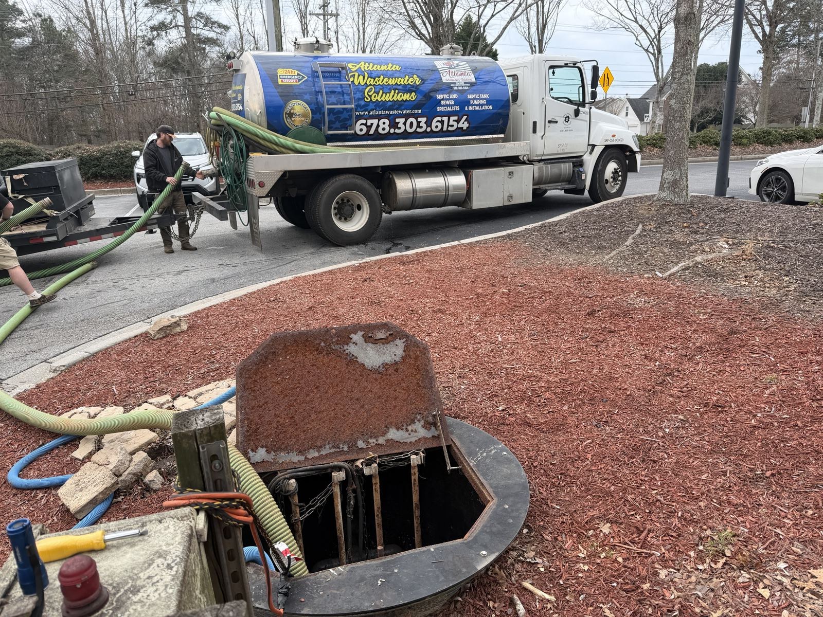 Technician working a septic tank access point during service — Septic Tank Repair in Cumming, GA